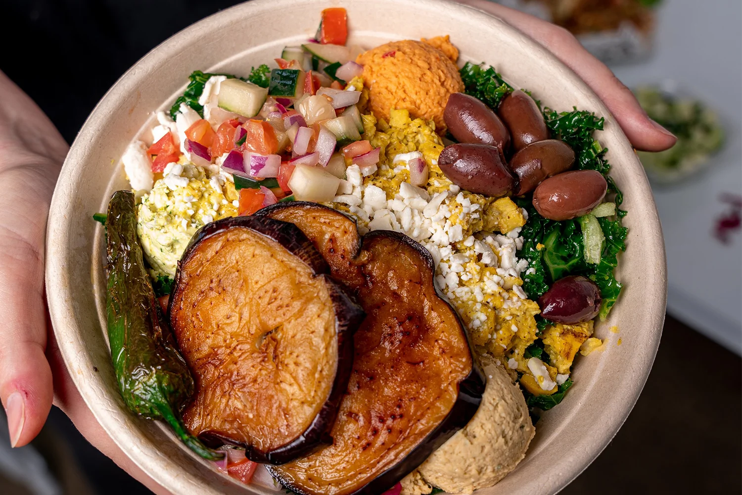 Why Plant-Forward Eating Is Reshaping the Fast Casual Landscape — and What It Means for Investors Freshly prepared plant forward fast casual franchise bowls with hummus, falafel, and Mediterranean toppings on a clean restaurant counter under warm natural light