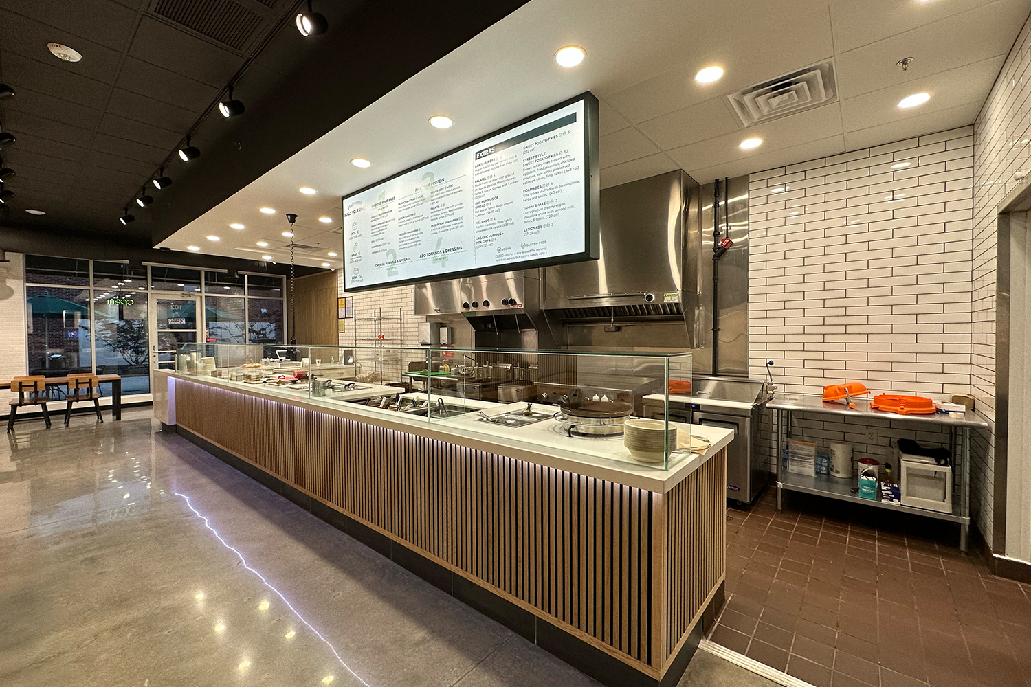 Why a Simple, Focused Menu Is Actually a Competitive Advantage for Owners Clean overhead menu board at a fast casual restaurant with clean menu showing a focused selection of Mediterranean dishes including hummus bowls and shawarma wraps