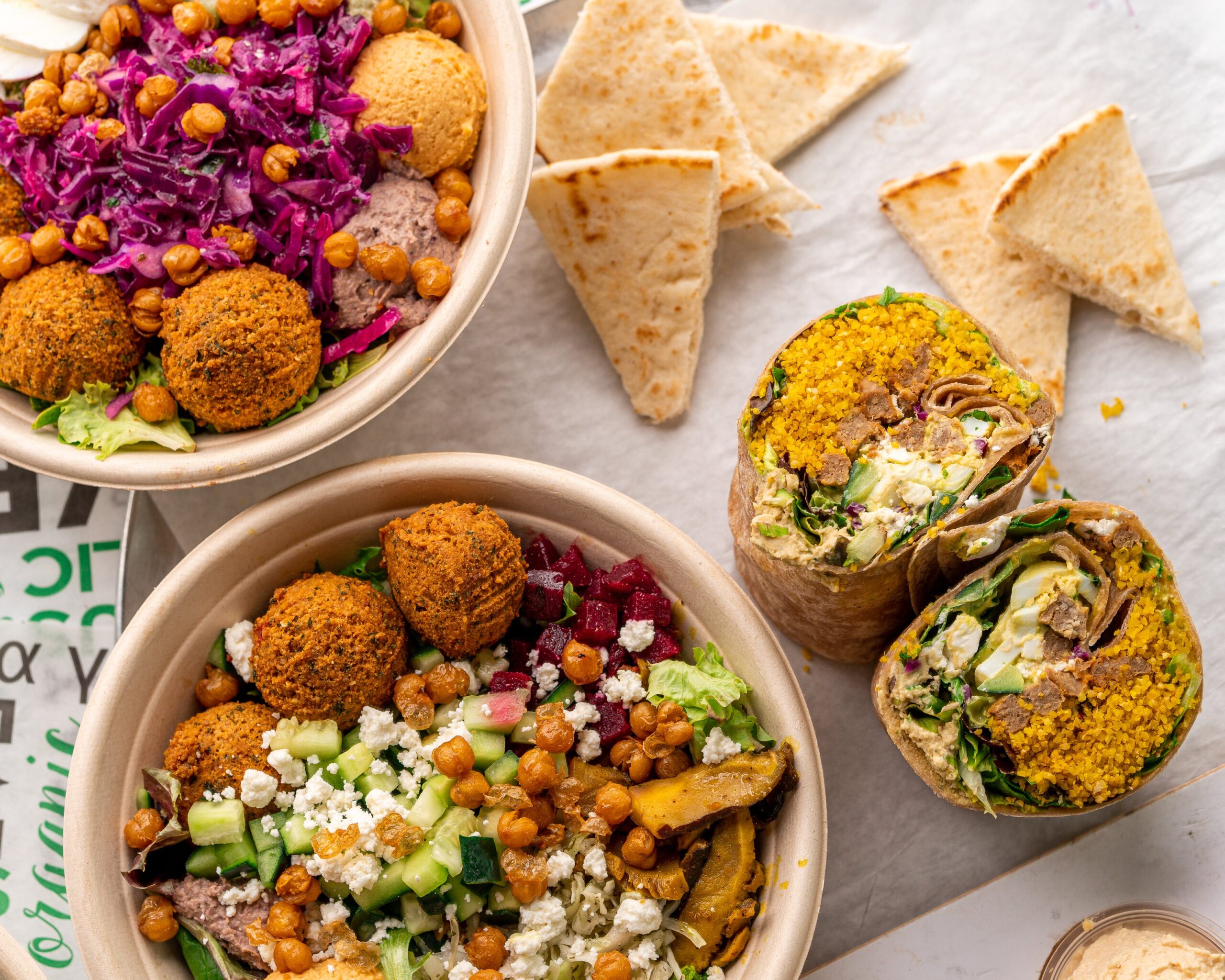 Why the Best Marketing for a Mediterranean Restaurant Is Already in Your Neighborhood A fresh Mediterranean fast-casual restaurant counter displaying hummus bowls and shawarma wraps — the kind of franchise with word of mouth growth built into every plate served