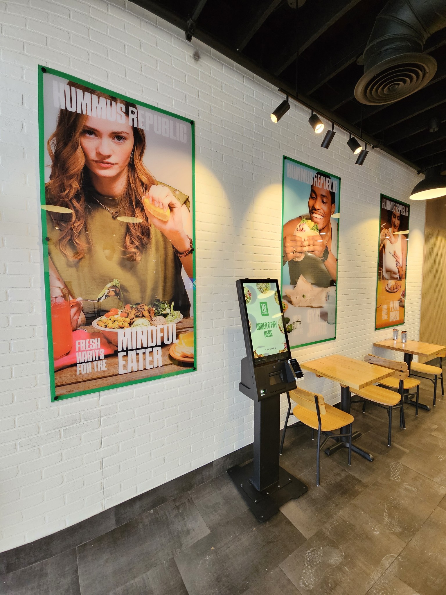 How a Food Business Becomes a Community Anchor — Not Just a Restaurant A proud restaurant owner standing behind a counter of fresh Mediterranean food, representing a food franchise that serves diverse communities with authentic flavors.